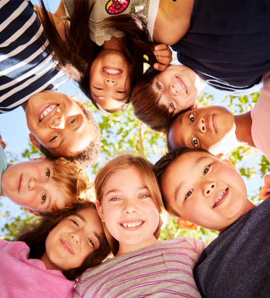 Children smiling together outdoors in a circle